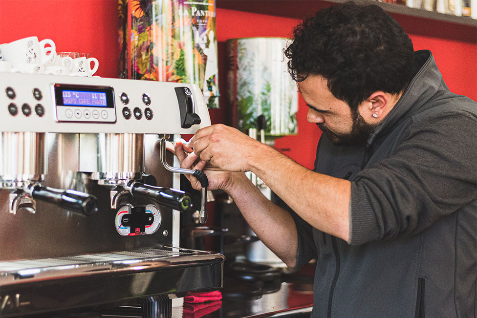 Servimatic technician offering technical assistance and repairing a coffee machine in a bar